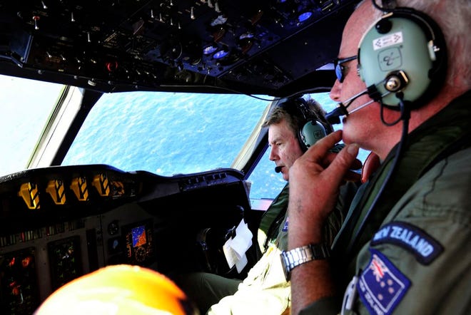 Royal New Zealand Air Force (RNZAF) co-pilot and squadron leader Brett McKenzie, left, and flight engineer Trent Wyatt sit in the cockpit aboard a P-3 Orion en route to search the southern Indian Ocean for missing Malaysia Airlines Flight 370, Friday, April 11, 2014. Authorities are confident that signals detected in the ocean are from the jet's black boxes, Australian Prime Minister Tony Abbott said, raising hopes they are close to solving one of aviation's most perplexing mysteries. (AP Photo/Richard Polden, Pool)