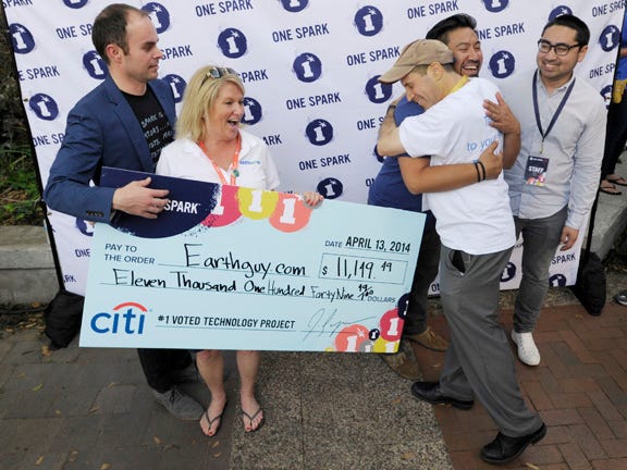 Hunter Johnson, the VP of Earth Guy and Davide Schwartz, the Founder and CEO celebrate their win with the One Spark Founders (left to right) Elton Rivas, Varick Rosete and Dennis Eusebio after being presented with their check for $11,149.49 after being crowd voted the top technology project.