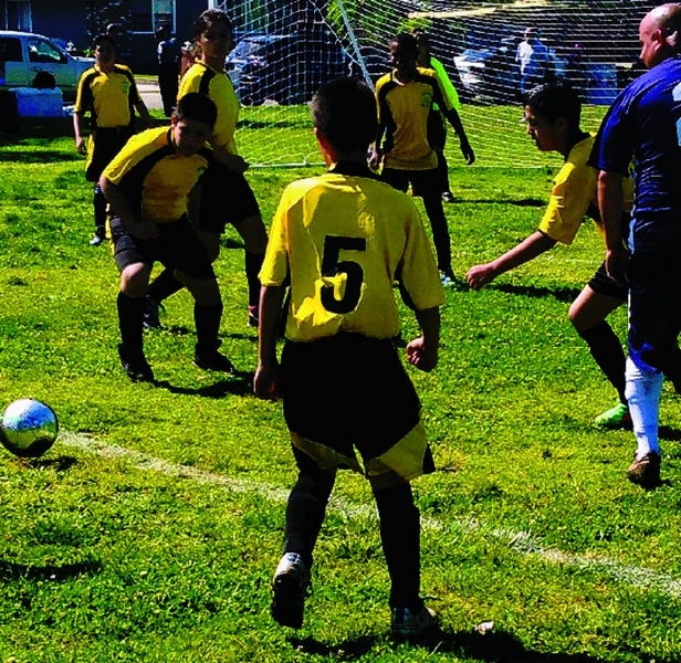 Stockton police Officer Luis Talamantes, right, was among a group of officers taking on members of the Kentfield Action Team’s Youth Soccer Club in an exhibition match Saturday morning at Weberstown Park.