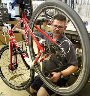 Jeremy Hutsell, service manager for Capp's Bike Shop and Fitness, works on a bike at the store, 2917 S.W. Topeka Blvd.