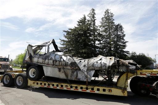 The demolished remains of a FedEx truck is towed into a CalTrans maintenance station in Willows, Calif., Friday, April 11, 2014. At least ten people were killed and dozens injured in the fiery crash on Thursday, April 10, between a FedEx truck and a bus carrying high school students on a visit to a Northern California college.