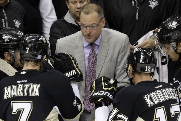 Pittsburgh Penguins head coach Dan Bylsma, center, gives instructions during a third-period time out in an NHL hockey game against the Carolina Hurricanes in Pittsburgh Tuesday, Oct. 8, 2013. The Penguins won 5-2. (AP Photo/Gene J. Puskar)