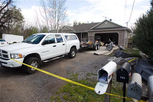 Authorities investigate a crime scene at a house in Pleasant Grove Utah, Sunday, April 13, 2014. According to the Pleasant Grove Police Department, seven dead infants were found in the former home of Megan Huntsman, 39. Huntsman was booked into jail on six counts of murder.