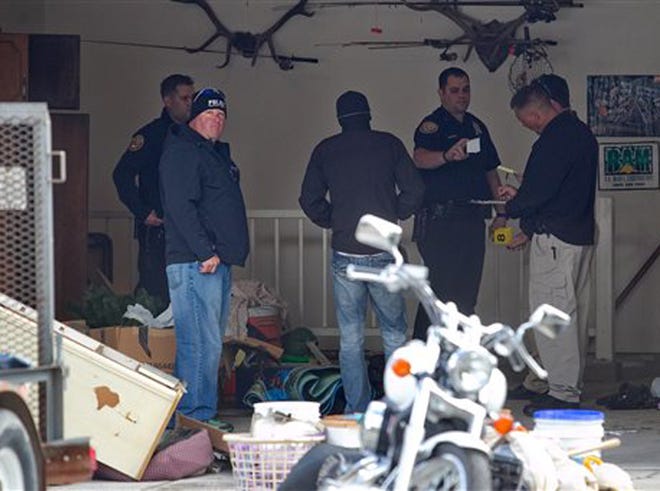 Authorities investigate a crime scene at a house in Pleasant Grove, Utah, Sunday, April 13, 2014. According to the Pleasant Grove Police Department, seven dead infants were found in the former home of Megan Huntsman, 39. Huntsman was booked into jail on six counts of murder.