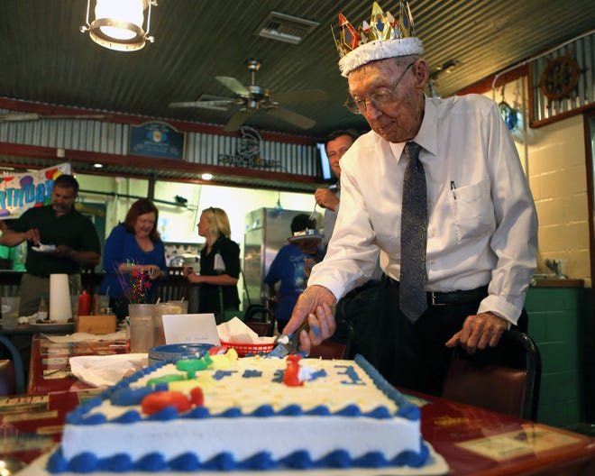 Ellis Fowhand cuts his birthday cake. Fowhand turned 100 Tuesday.