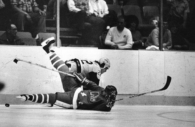 Quebec Nordiques' Peter Stastny, (26), hits the ice after being crosschecked by Penguins' Bryan Maxwell, (5), in the crease in front of Penguins' goalie Denis Herron, (1), during first period NHL action March 9, 1984 in Pittsburgh.