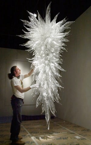 Ernesto Sanchez dusts the Waterford lead crystal chandelier that was originally in the Dale Chihuly glass art exhibit in the new Oklahoma City Museum of Art on March 7, 2002. The chandelier remains a favorite piece in the museum's current downtown home, which opened in March 2002 to long lines and great excitement. [The Oklahoman Archives]
