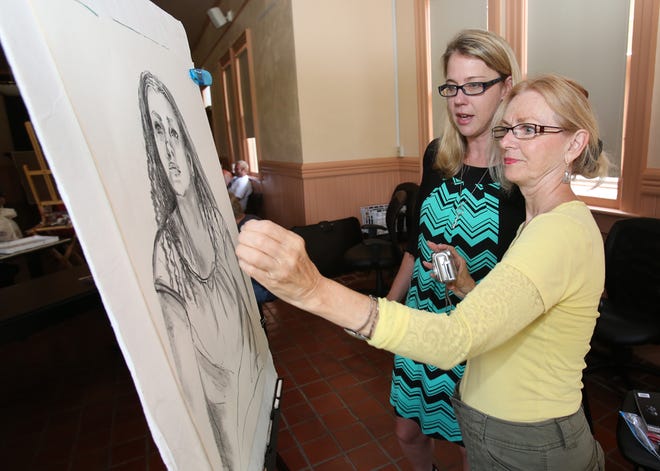 Melissa Townsend, the community cultural arts manager for the City of Ocala, left, talks with Vicki Carol of the Ocala Art Group, right, as Carol works on a charcoal drawing with a live model at Ocala Union Station in Ocala, Fla. on Monday, April 14, 2014.