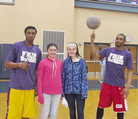 Harlem Wizard Steven “Jumping Jack” Harris, left, poses with Cooperative Middle School students Lauren Scott and Grace White, and Harlem Wizard teammate Devon “Live Wire” Curry.