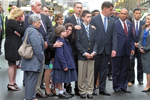 The Richard family along with Boston Mayor Marty Walsh and Massachusetts Gov. Deval Patrick participate in a wreath laying ceremony to commemorate the one year anniversary of the Boston Marathon bombings, Tuesday, April 15, 2014, in Boston. Martin Richard was killed in the bombing.
