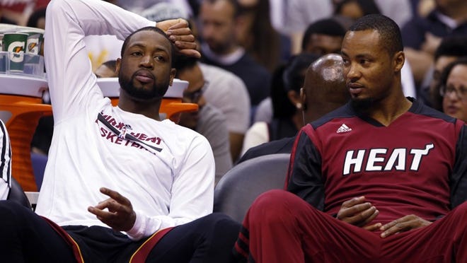 Miami Heat guard Dwyane Wade, left, and forward Rashard Lewis rest on the bench in the second half of an NBA basketball game against the Washington Wizards, Monday, April 14, 2014, in Washington. The Wizards won 114-93. (AP Photo/Alex Brandon)