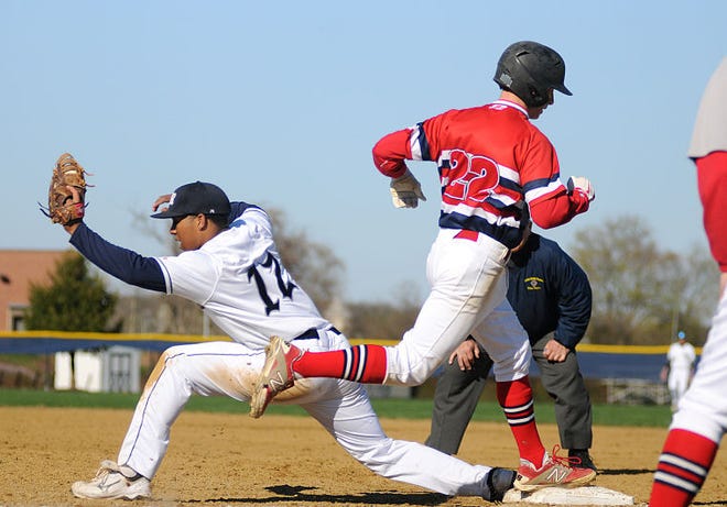 Council Rock North's Brandon McIlwain (12) tags out Neshaminy's Ryan Sheplock (22) on first during their 6-5 win at home on Wednesday afternoon.