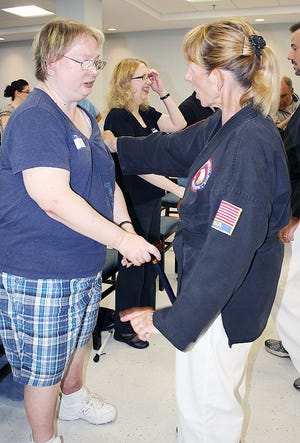 Lisa Simons, a customer service representative in CABVI’s call center, receives self-defense instruction from Cheryl Freleigh of the American Marshall Arts Institute in Utica. SUBMITTED PHOTO