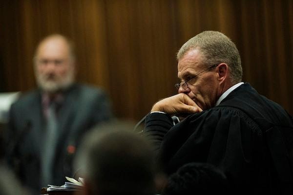Forensic investigator, Roger Dixon, back left, is questioned by state prosecutor Gerrie Nel, foreground, during the murder trial of Oscar Pistorius in court in Pretoria, South Africa, Wednesday, April 16, 2014. Pistorius is charged with the murder of his girlfriend, Reeva Steenkamp, on Valentines Day in 2013. THE ASSOCIATED PRESS