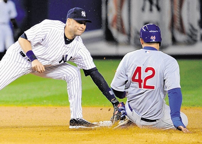 Derek Jeter, left, tags out Cubs’ Anthony Rizzo in the fourth inning of Game 2 on Wednesday night.