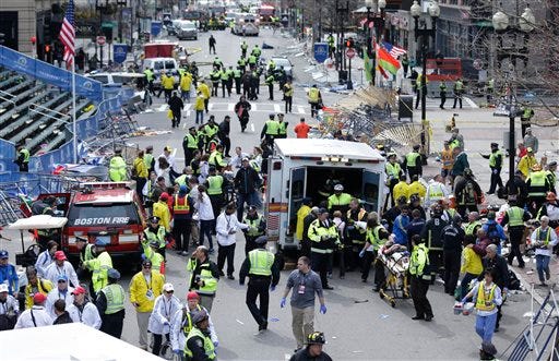Medical workers aid injured people following an explosion at the finish line of the 2013 Boston Marathon in Boston.