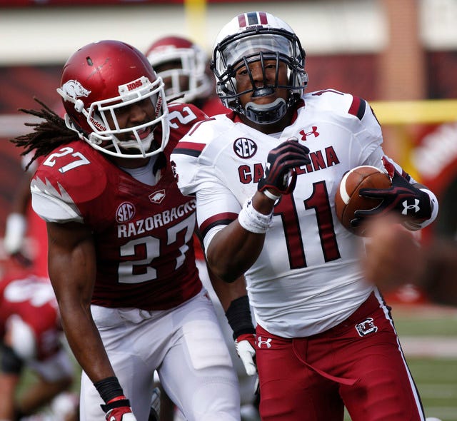 Marc F. Henning * Arkansas News Bureau Arkansas safety Alan Turner, left, chases South Carolina returner Pharoh Cooper on a 33-yard wildcat carry during the Razorbacks' game Oct. 12 against the Gamecocks at Reynolds Razorback Stadium in Fayetteville. 
 Mark Buffalo * Arkansas News Bureau
Arkansas cornerback Tevin Mitchel returns an interception for a touchdown against Rutgers at Highpoint Solutions Stadium in Piscataway, N.J.