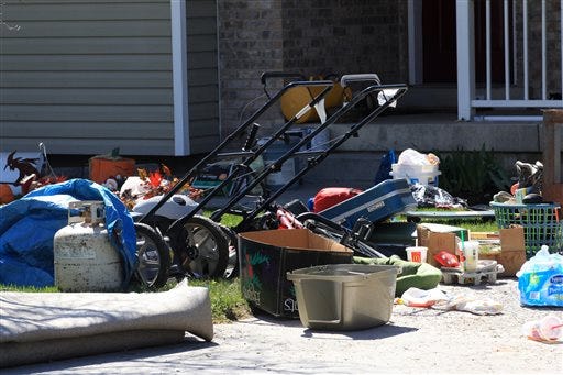 Belongings are shown on the ground in front of the garage where seven infant bodies were discovered and packaged in separate containers at a home in Pleasant Grove, Utah, Monday, April 14, 2014. Authorities say a Utah woman accused of killing six babies that she gave birth to over 10 years told investigators that she either strangled or suffocated the children and then put them inside boxes in her garage. According to a probable cause statement released by police Monday, Megan Huntsman said that between 1996 and 2006, she gave birth to at least seven babies at her home and that all but one of them were born alive. (AP Photo/Rick Bowmer)