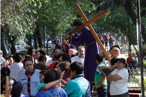 People who were participating in a Holy Week procession stop after a strong earthquake jolted Mexico City, Friday, April 18, 2014. A powerful magnitude-7.2 earthquake shook central and southern Mexico but there were no early reports of major damage or casualties. (AP Photo/Marco Ugarte)