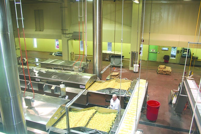 Jerome Nicholson monitors the automated line turning out Gibble’s Homestyle Potato Chips. Tuesday was the second day of operation at the plant, after it was shut down a year ago.
