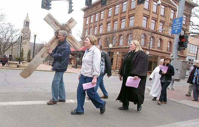 Clergy from several Corning churches walk along Market Street in Corning during Friday's Stations of the City walk.