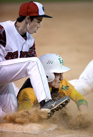 Graham's Joe Hartnett tags out Eastern Alamance's Mark Law at third base during a semifinal of the Graham Boosters Easter Tournament on Friday night.