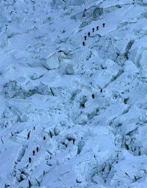FILE - In this Sunday, May 18, 2003 file photo, mountaineers pass through the treacherous Khumbu Icefall on their way to Mount Everest near Everest Base camp, Nepal. An avalanche swept down a climbing route on Mount Everest early Friday, killing at least 12 Nepalese guides and leaving three missing in the deadliest disaster on the world's highest peak. (AP Photo/Gurinder Osan, file)