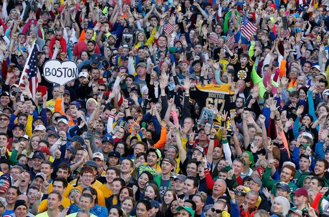 A crowd gathers at the finish line of the Boston Marathon in Boston for a Sports Illustrated photo shoot before the one-year anniversary of the Boston Marathon bombings, Saturday, April 12, 2014. (AP Photo/Michael Dwyer)