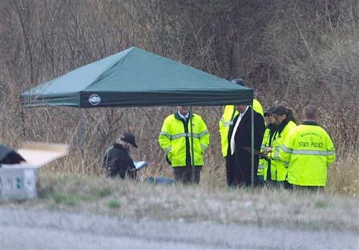 Massachusetts State Police stand along Interstate 190 where police said a child's body was found Friday, April 18, 2014, near Sterling, Mass.