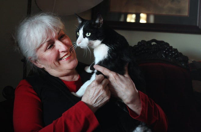 Cheryl Hartman listens to the purr of her cat Baby at her home in Freeport. Hartman follows a strict recipe of food when it comes to feeding her 15-year-old feline.