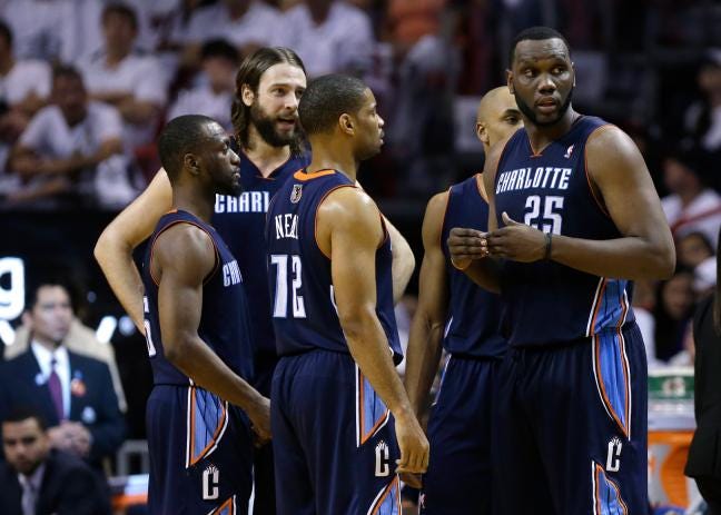 Charlotte's Al Jefferson (25) talks with Kemba Walker, left, Josh McRoberts, second from left, and Gary Neal (12) during the second half in Game 1 of an opening-round playoff series against the Miami Heat on Sunday in Miami. The Heat defeated the Bobcats 99-88.