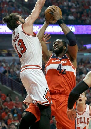 Washington Wizards forward Nene, right, drives to the basket against Chicago Bulls center Joakim Noah during the first half in Game 1 of an opening-round NBA basketball playoff series in Chicago, Sunday, April 20, 2014.