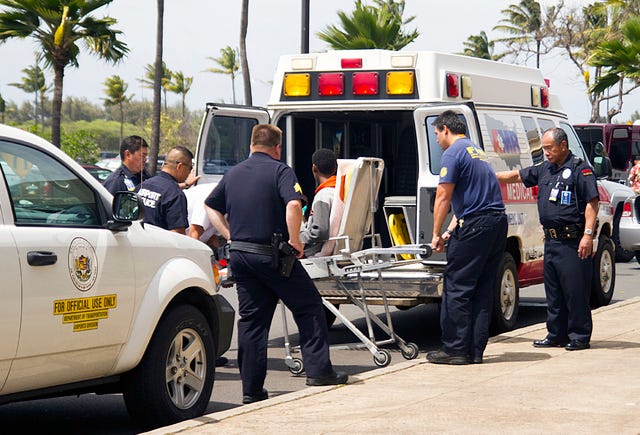 THE ASSOCIATED PRESS / A 16-year-old boy, seen sitting on a stretcher center, who stowed away in the wheel well of a flight from San Jose, Calif., to Maui is loaded into an ambulance at Kahului Airport in Kahului, Maui, Hawaii Sunday afternoon, April 20, 2014. The boy survived the trip halfway across the Pacific Ocean unharmed despite frigid temperatures at 38,000 feet and a lack of oxygen, FBI and airline officials said. FBI spokesman Tom Simon in Honolulu told The Associated Press on Sunday night that the boy was questioned by the FBI after being discovered on the tarmac at the Maui airport with no identification. "Kid's lucky to be alive," Simon said. (AP Photo/The Maui News, Chris Sugidono)
