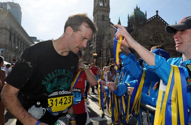 Shane O’Hara, of Raynham, receives his medal after running in the 118th Boston Marathon on Monday.