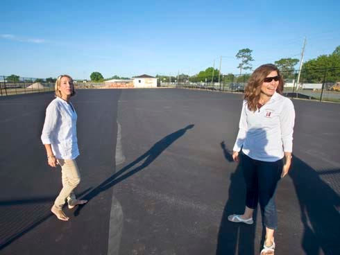 Beth Watkins, left, and Cici Hruby stand on the new courts of the Eagle Ram Tennis Center Tuesday. The project, which was entirely privately funded, will eventually have eight courts, nighttime lighting and two courts for children ages 10 and under.
