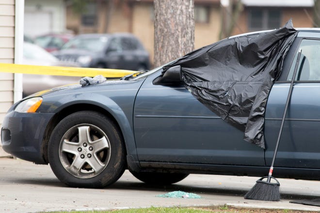 Plastic covers a broken car window at the scene of a shooting Monday, April 21, 2014, at Cameron and North Rockton avenues in Rockford.