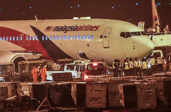 Ground crew check the Malaysia Airlines flight MH192 bound for Bangalore that turned back towards and parked at Kuala Lumpur International Airport in Sepang, Malaysia, Monday, April 21, 2014, after its right landing gear malfunctioned upon takeoff. The airline says Flight 192 carrying 166 people landed safely at the Kuala Lumpur International Airport early Monday, four hours after it departed. THE ASSOCIATED PRESS