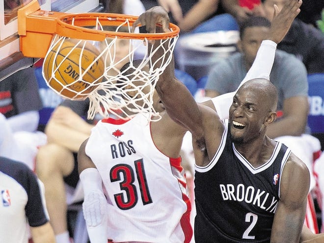 Kevin Garnett, right, slams one home in the second half against the Raptors on Tuesday night.