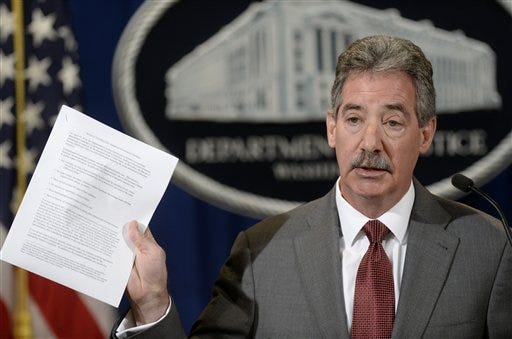 Deputy Attorney General James Cole hold up a list of guidelines during a news conference at the Justice Department in Washington, Wednesday, April 23, 2014. Cole announced the new standards that will be considered in deciding whether to recommend clemency for certain non-violent drug prisoners. Wednesday's announcement is part of an ongoing effort to trim the nation's prison population and help convicts who were given what the Obama administration says were unduly harsh sentences for drug crimes.