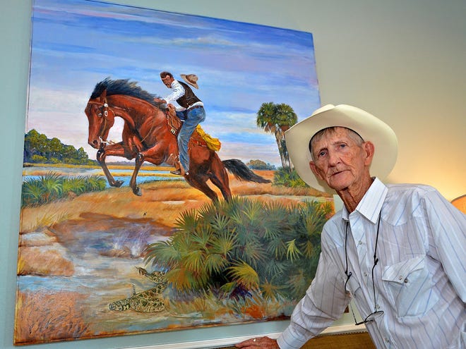 Local artist Bill Roberts stands next to one of his cowboy paintings. The large painting is inside his daughter's home in Ocala.