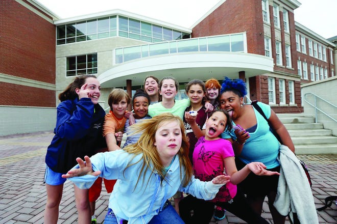 Portsmouth Middle School students gather by the main entrance of the school and squeeze together for a photo while they wait for busses on Wednesday.