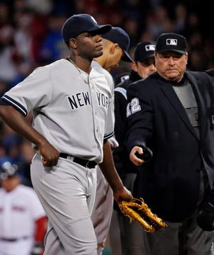 Home plate umpire Gerry Davis, right, ejects Yankees pitcher Michael Pineda, left, after a foreign substance was discovered on his neck in the second inning. The Red Sox won, 5-1. THE ASSOCIATED PRESS