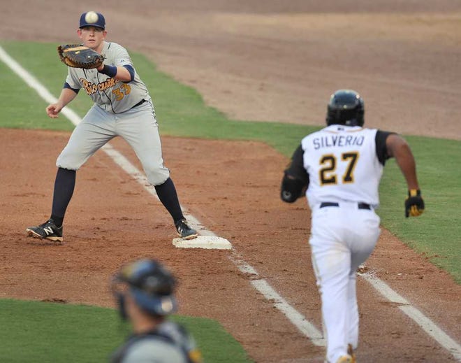 Bob.Self@jacksonville.com- Suns outfielder Alfredo Silverio sprints to first after the catcher dropped the ball on a third strike during the second inning as Biscuits first baseman Cameron Seitzer waits for the throw on Thursday at the Baseball Grounds of Jacksonville.