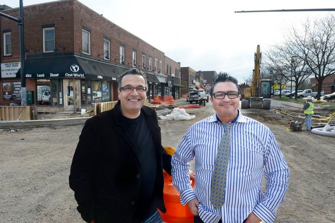 One World Cafe owners and brothers Bob, left, and Sam Eid pause in the center of the construction zone outside of their West Main St. business Thursday. Main Street business owners are wlecoming the changes however they are looking forward to completion of the work at the intersection that has had a negative effect on business.