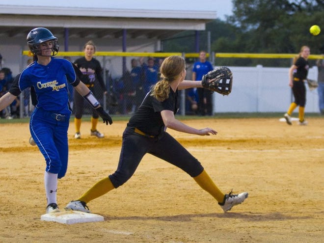 Crystal Rivers' #14 Haley Coleman makes it to first base before Lake Weir's #11 Olivia Evans makes the catch in the Region 5A-2 softball quarterfinals. Lake Weir fell to Crystal River 11-7 at Lake Weir High School in Candler, Florida, April 24, 2014.