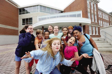 Portsmouth Middle School students gather by the main entrance of the school and squeeze together for a photo while they wait for buses on Wednesday.