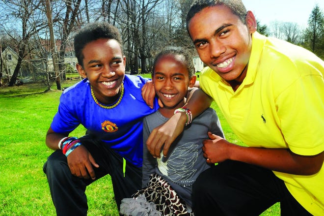Behaylu Barry of Stratham, right, with his sister, Eden, 9, and brother Rediat, 18, both from Ethiopia, have a short race in the backyard before they travel to Boston Thursday. Eden and Rediat are matches for Behaylu's life-saving bone marrow transplant and they will be tested at Children's Hospital.