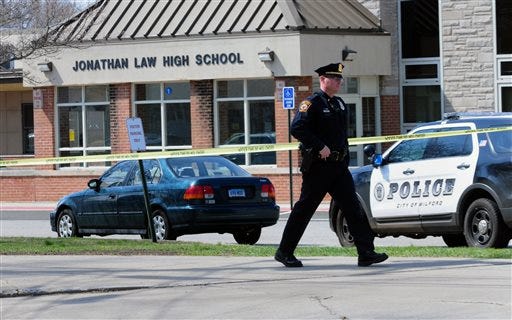 Police remain on scene at Jonathan Law High School after a 16-year-old girl was stabbed to death in Milford, Conn., Friday, April 25, 2014. A teenage boy is in custody, and police are investigating whether the attack stemmed from her turning down an invitation to be his prom date. (AP Photo/The New Haven Register, Peter Hvizdak)
