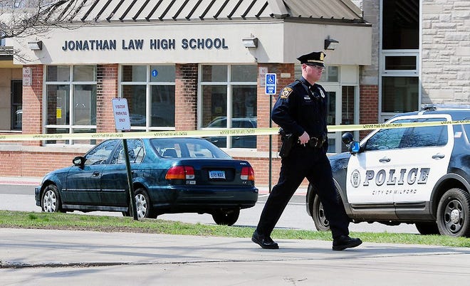 Police remain on scene at Jonathan Law High School after a 16-year-old girl was stabbed to death in Milford, Conn., Friday. A teenage boy is in custody, and police are investigating whether the attack stemmed from her turning down an invitation to be his prom date. AP PHOTO/THE NEW HAVEN REGISTER/PETER HVIZDAK