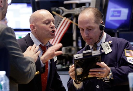 FILE - Traders Daniel Leporin, left, and Michael Urkonis work on the floor of the New York Stock Exchange in this April 23, 2014 file photo. Global stocks tumbled Friday April 25, 2014 after tensions over Ukraine mounted and Standard & Poor's cut Russia's credit rating, warning of capital flight and risks to investment due to the crisis. (AP Photo/Richard Drew, File)